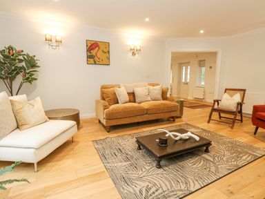 A living room with sofas armchair coffee table rug and a plant at Sunningdale Rise in Preston