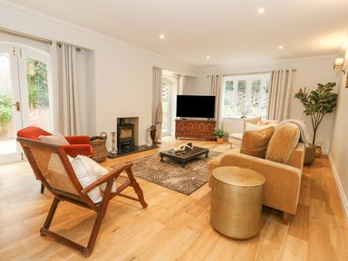 A living room with chairs a coffee table a television and a fireplace at Sunningdale Rise in Preston