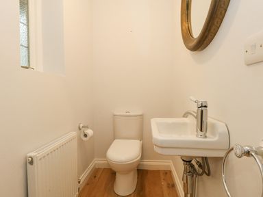 A small bathroom with a toilet sink mirror and radiator at Sunningdale Rise in Preston
