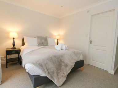 A bedroom with a bed lamps on bedside tables and a door at Sunningdale Rise in Preston
