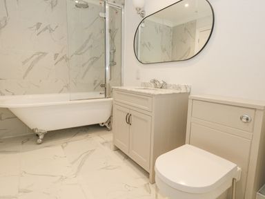A bathroom with a clawfoot bathtub sink cabinet mirror and toilet at Sunningdale Rise in Preston