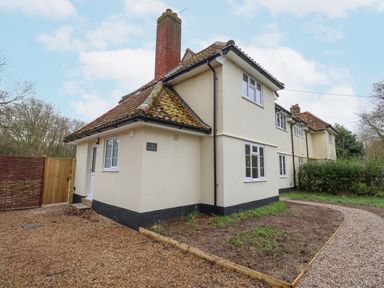 A cream colored house with a tiled roof a gravel driveway and a garden at 3 Chantry Cottages Campsea Ashe near Woodbridge