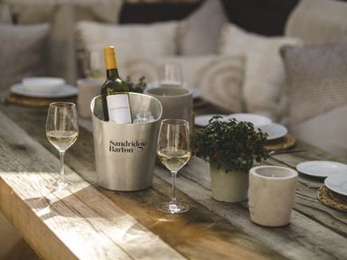 A dining area with wine and glasses at Lower Well Farm House in Totnes