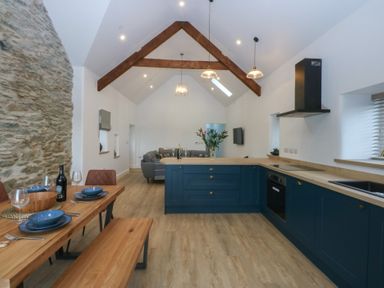 A kitchen with a dining table and sofa at Beudy