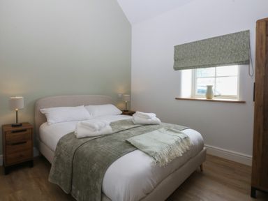 A bedroom with a bed and nightstand at Beudy