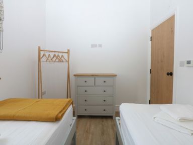 A bedroom with a bed, dresser, and wardrobe at Beudy