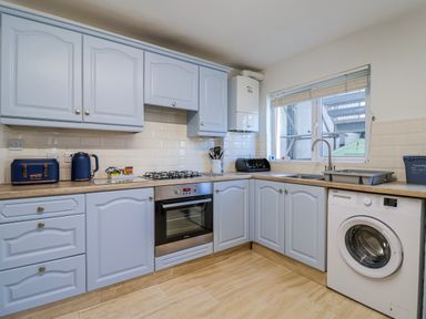 A kitchen with blue cabinets and appliances at Sea Lovers in Exmouth