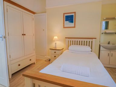 A bedroom with a bed and a wardrobe at Sea Lovers in Exmouth