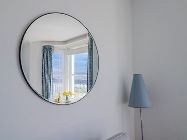 A dining room with a mirror and flowers at Sea Lovers Exmouth