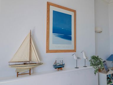A display with a sailboat, boat model, bird figurines, and a plant at Sea Lovers in Exmouth