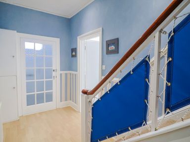 A hallway with a staircase and door at Sea Lovers in Exmouth