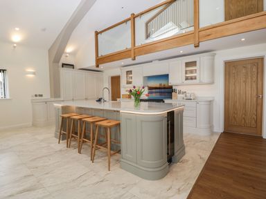 A kitchen with a large island and wooden stools at Hidden Well in Aust