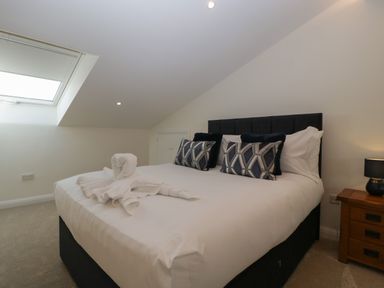 A bedroom with a double bed two pillows and a bedside table with a lamp at Hidden Well in Aust