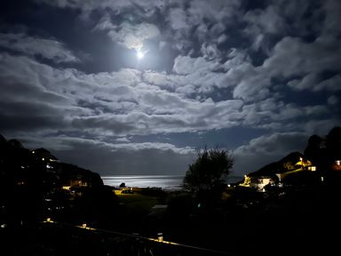 A night view of the ocean with moonlight and clouds at Shells Cottage in Looe