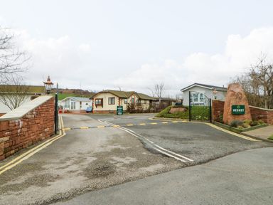 An entrance gate to a residential area with houses and a sign that says Hesket at A and C Lodge-Plot 21 in Armathwaite