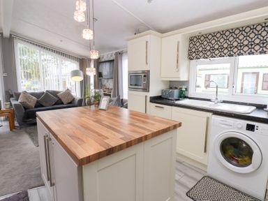 A kitchen with a wooden island and appliances at A and C Lodge-Plot 21 Armathwaite