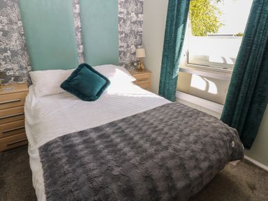 A bedroom with a bed and bedside table at A and C Lodge-Plot 21 Armathwaite