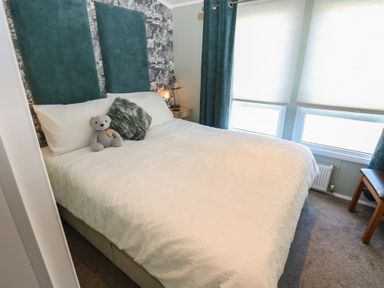 A bedroom with a bed and teddy bear at A and C Lodge-Plot 21 Armathwaite