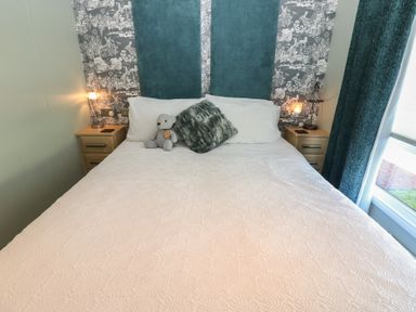 A bedroom with a bed and nightstands at A and C Lodge-Plot 21 Armathwaite