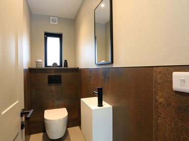 A small bathroom with a toilet a sink a mirror and a window at The Barns @ Downton in Dittisham