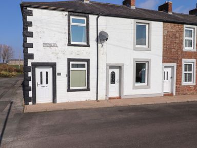 A row of three connected houses with white doors and windows on South Street at 2 South Street Fletchertown near Aspatria