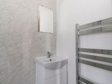 A bathroom with a sink and mirror and a stainless steel towel radiator at 2 South Street in Fletchertown near Aspatria
