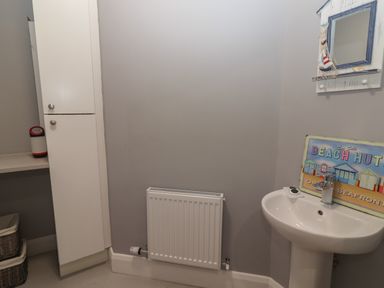 A bathroom with a sink radiator and cabinet at The Boathouse in Carrigaholt County Clare
