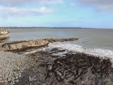 A rocky shoreline with waves coming in at The Boathouse in Carrigaholt County Clare