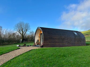 A cabin in a grassy area at Willow Llangurig near Llanidloes