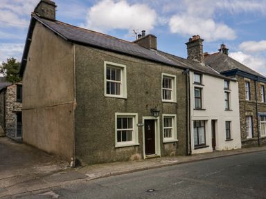 A row of attached houses with windows and chimneys along a street at Eden Vale in Broughton-In-Furness