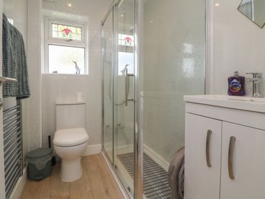 A bathroom with a toilet shower enclosure sink cabinet and a towel rail at Cassia Kilkhampton