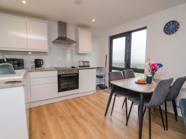 A kitchen with appliances and dining area at Cassia in Kilkhampton
