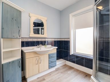 A bathroom with a sink cabinet mirror window and shower enclosure at 46 The Promenade in Withernsea