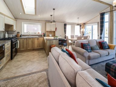 An open plan kitchen and living area with sofas and a dining table at Gressingham 7 in Warton near Carnforth