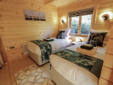 A bedroom with two single beds and a window at Little Lodge in Balminnoch near Glenluce
