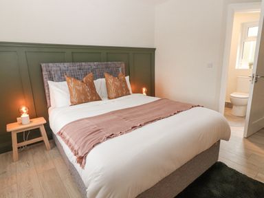 A bedroom with a bed pillows and bedside tables with lamps near a bathroom at Curhoor Near Loughrea County Galway