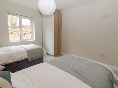 A bedroom with two beds a window and a wardrobe at Curhoor Near Loughrea County Galway