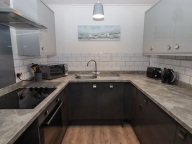 A kitchen with a stove oven microwave sink toaster and kettle at 19 Coedrath Park in Saundersfoot