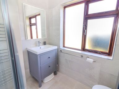 A bathroom with a sink cabinet mirror window and towel holder at Tonakilla House in Tonakilly near Camp County Kerry
