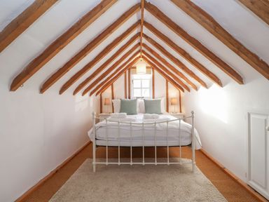 A bedroom with a bed under a wooden beam ceiling at Twosome in Chediston near Halesworth
