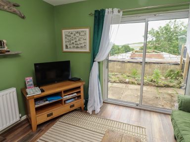 A living room with a television and a sofa at Flodden Apartment in Wooler