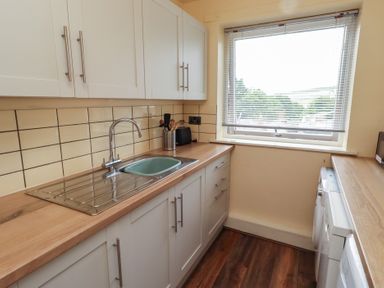 A kitchen with a sink and kitchen cabinets at Flodden Apartment in Wooler