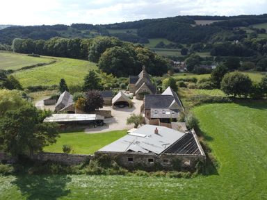 A rural property with multiple stone buildings and green fields at The Lodge at Wildersley Farm in Belper