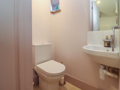 A small bathroom with a toilet sink and a small window at Blossom Cottage in Chipping Campden