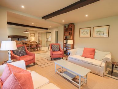 A living room with armchairs a sofa a coffee table a bookshelf and a dining table at Green Yew in Winster near Bowness-On-Windermere
