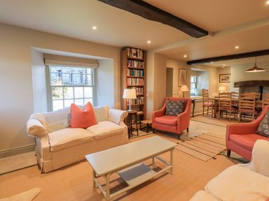 A living room with sofas chairs coffee table bookshelf and dining table at Green Yew in Winster near Bowness-On-Windermere