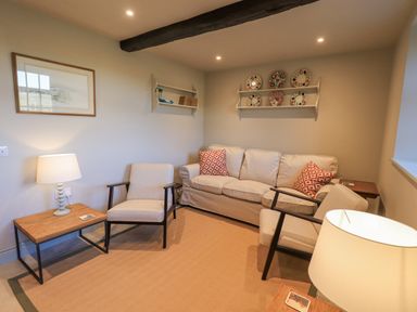 A sitting room with a sofa and two armchairs with side tables and lamps at Green Yew Winster near Bowness-On-Windermere