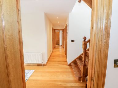 A hallway with wooden floors stairs and doors at Doonalton House in Dromore West County Sligo