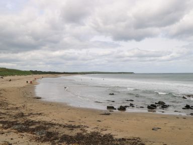 A beach view with people walking along the shore at Doonalton House Dromore West County Sligo