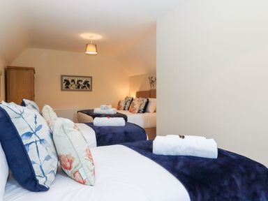 A bedroom with three beds with pillows and towels on each bed at Nempnett Farmhouse in Nempnett Thrubwell near Blagdon